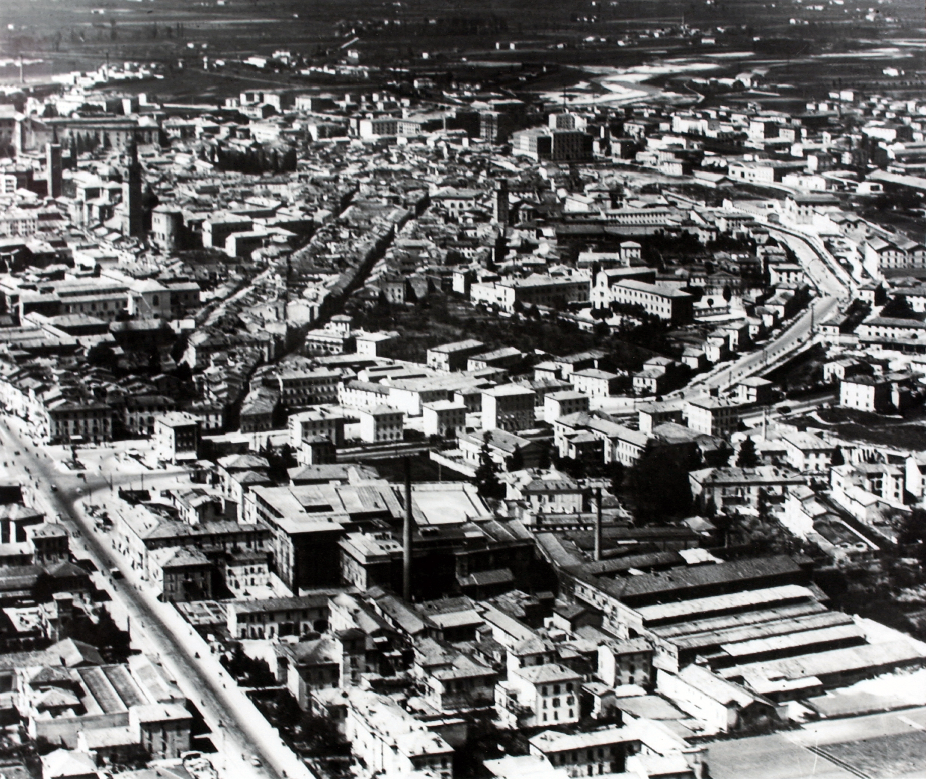 The extension of the factory emerges from the profile of the buildings in the urban fabric of Parma, here in a view from above dating to 1950 [ASB, Aa 502] in the eastern area immediately behind the old outline of the walls, touching via Emilia, visible i
