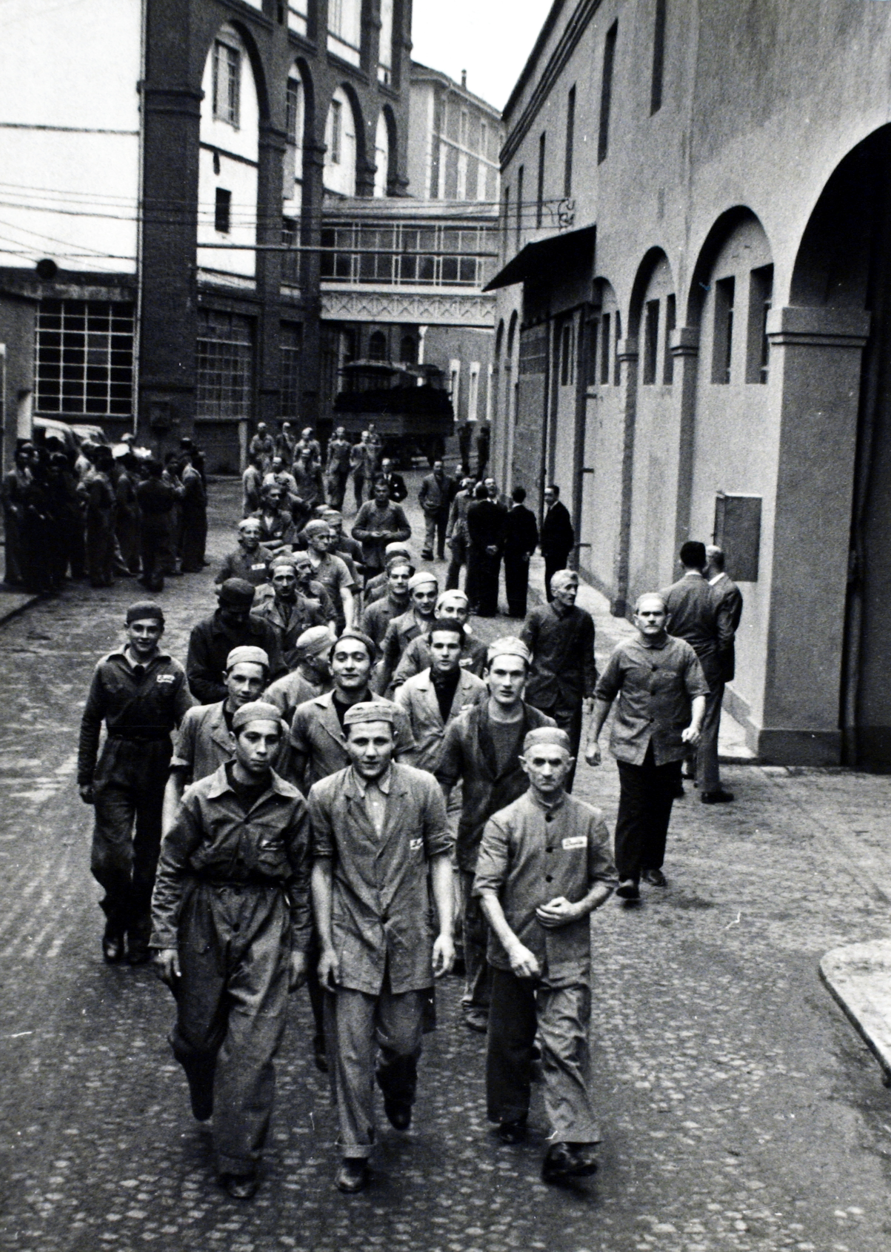 A view of the passage between the bakery (on the right) and the pasta plant (on the left) and workers walking through during the change of shift in 1940 [ASB, Aa 563].