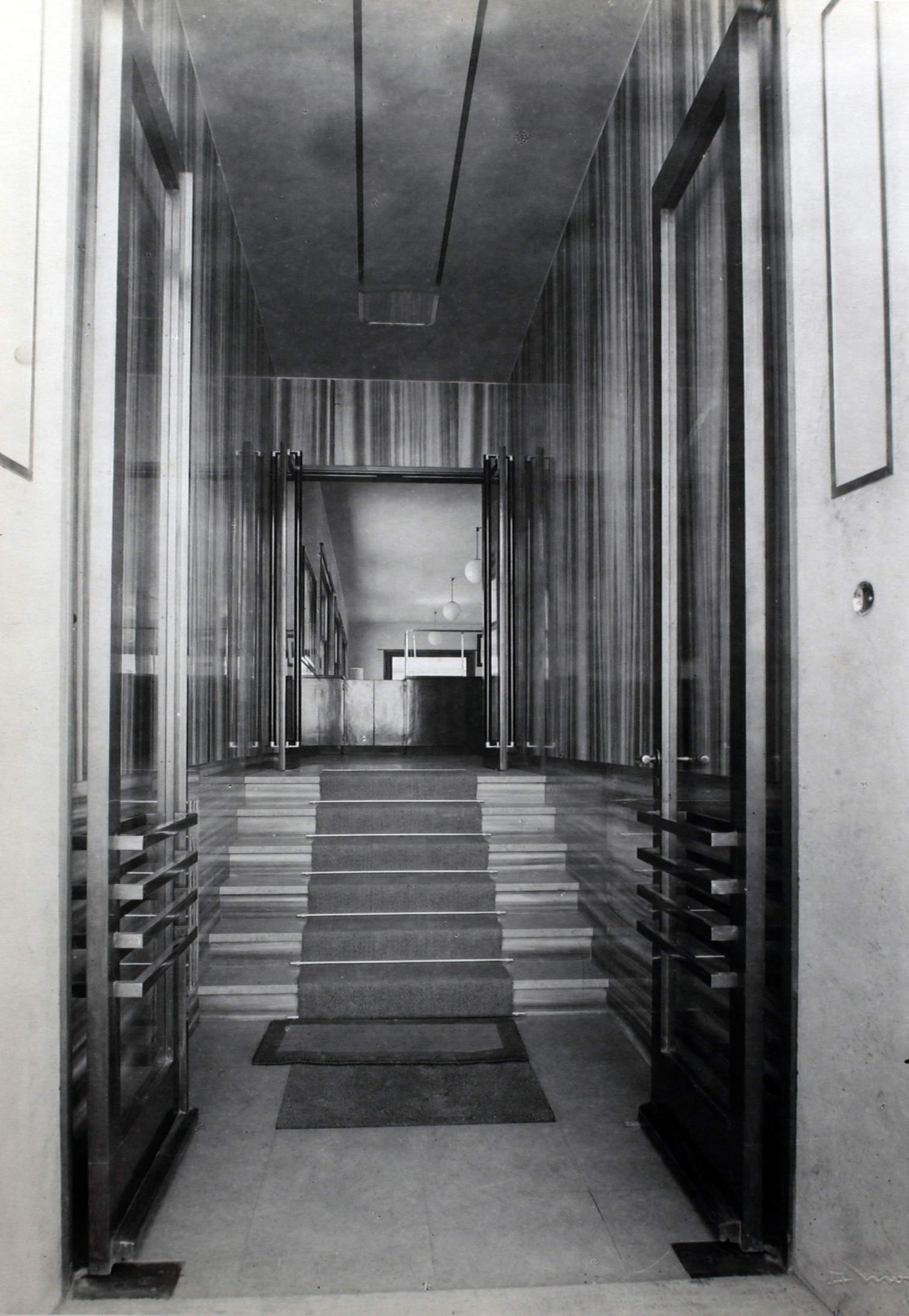 The entrance of the offices designed on the ground floor of the building by the architect Elsässer in a photo taken by Alberto Montacchini in 1934 [ASB, Aa 134].