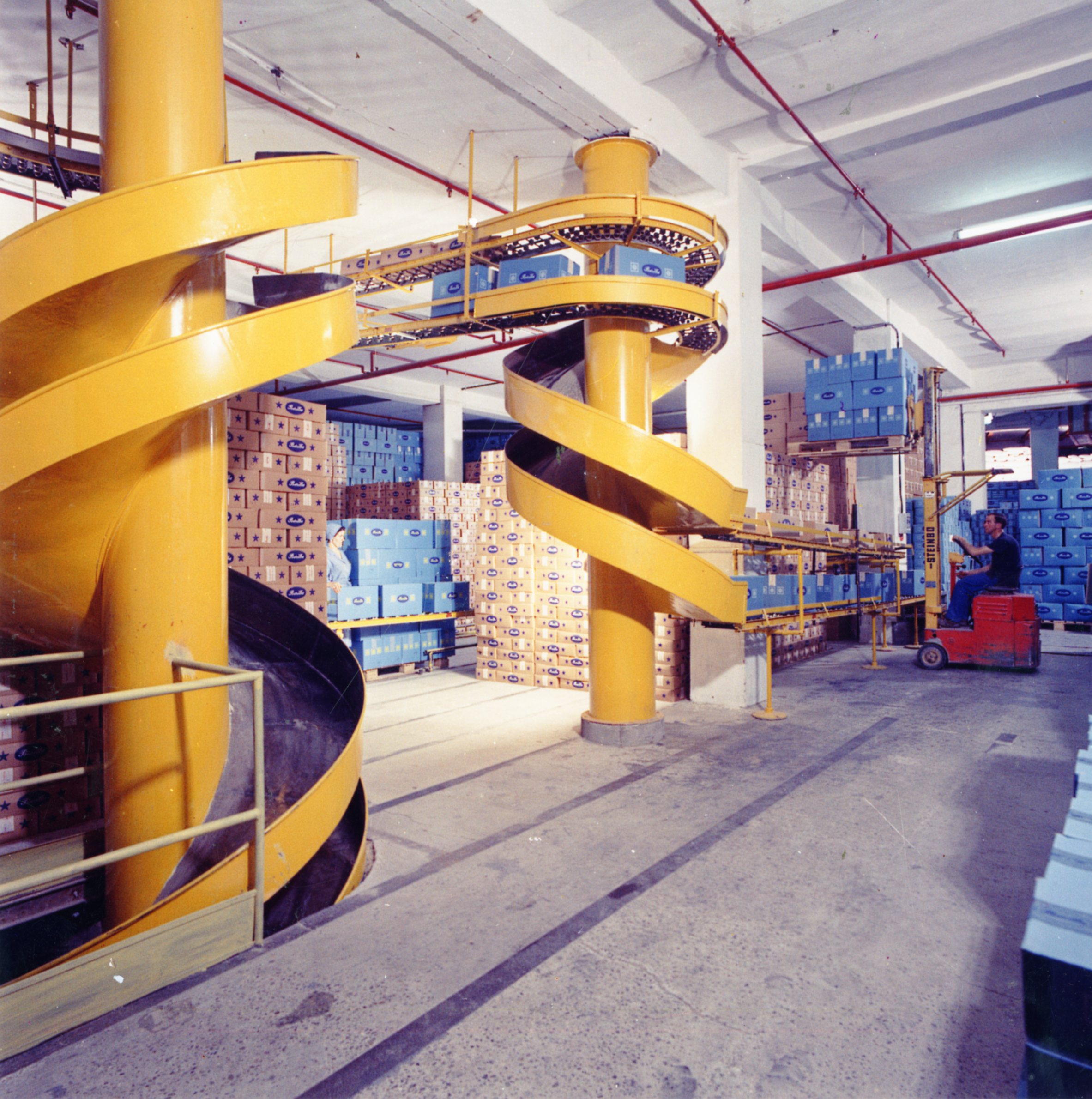 An inner view of the storage areas on ground level, characterized by helicoidal slipways to send down the packaged product in a photo by Bruno Vaghi dating from the early 1960s [ASB, O, Plants].