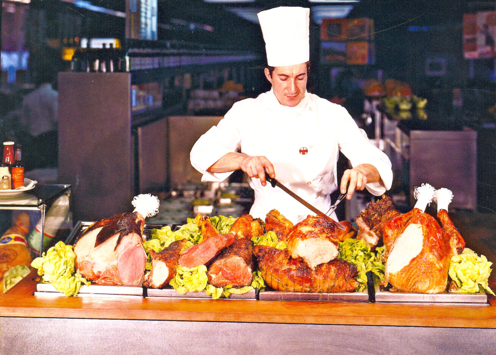 Cook of a Service Station in front of the cart for roasts