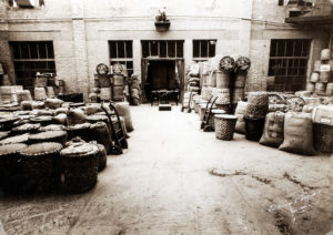 Con la carta per alimenti venivano anche foderati i “corbelli”, cesti di scorza di castagno utilizzati per le spedizioni ai negozianti. Qui il Reparto Spedizioni Barilla nel 1911 in una foto di Luigi Vaghi con, in primo piano, numerosi corbelli pronti per la spedizione [ASB, BAR I A 29].